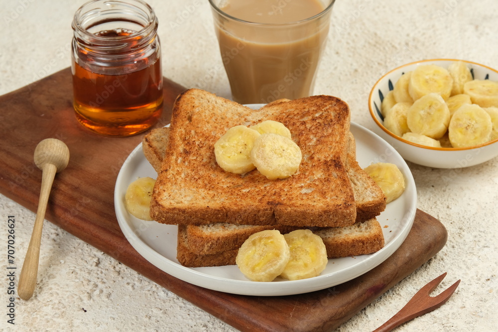 french toast with banana and honey on white background