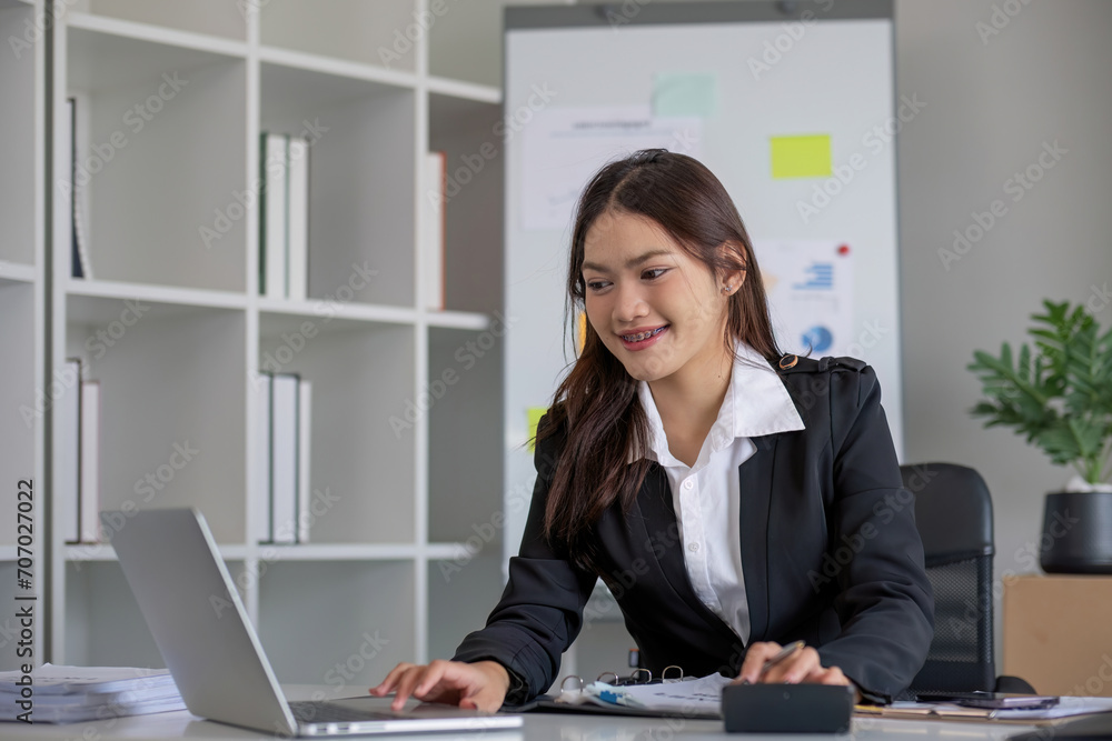 Business woman using calculator and laptop for do math finance on wooden desk in office and business working background, tax, accounting, statistics and analytic research concept Business woman using calculator and laptop for do math finance on wooden desk in office and business working background, tax, accounting, statistics and analytic research concept