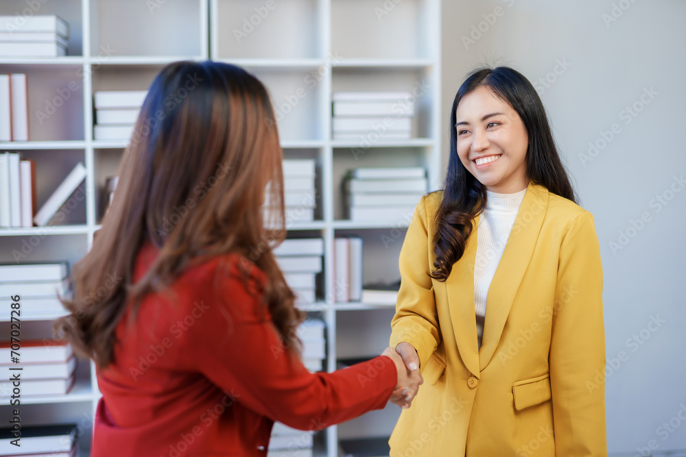 Young Asian businesswoman handshake to congratulate success. Young Asian businesswoman handshake to congratulate success.