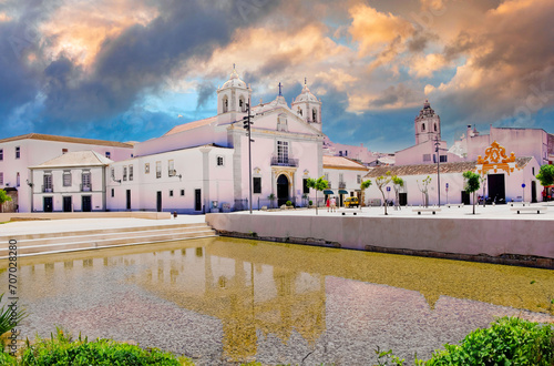 Tranquil Mediterranean Town Plaza with Reflective Pool, Historic Church, and Colorful Architecture, Southern Europe