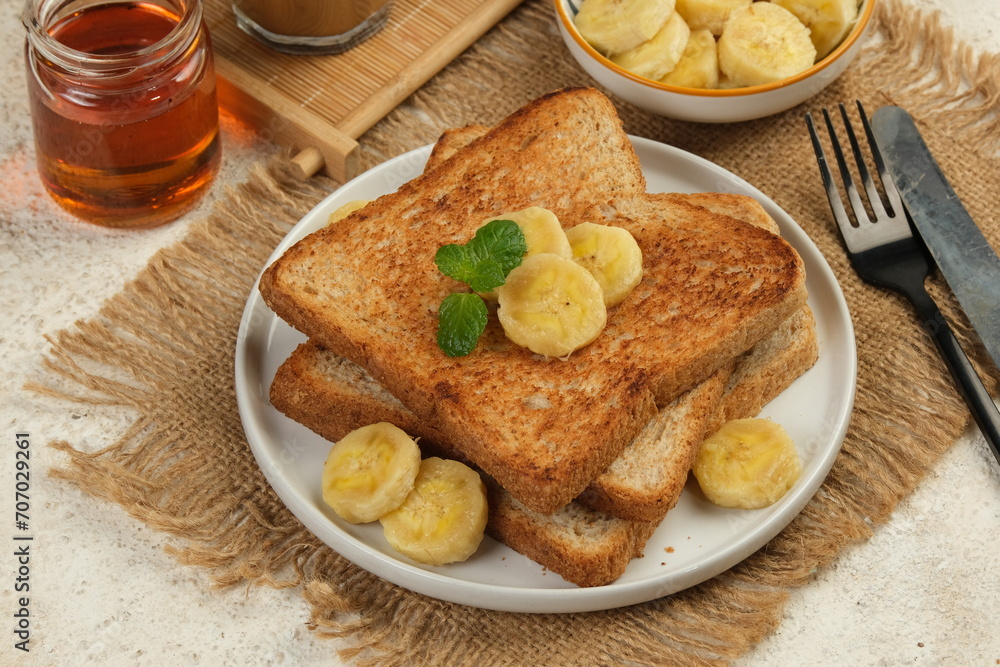 french toast with banana and honey on white background