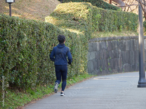 冬の東京都の皇居外苑の道で走るランナーの姿 photo