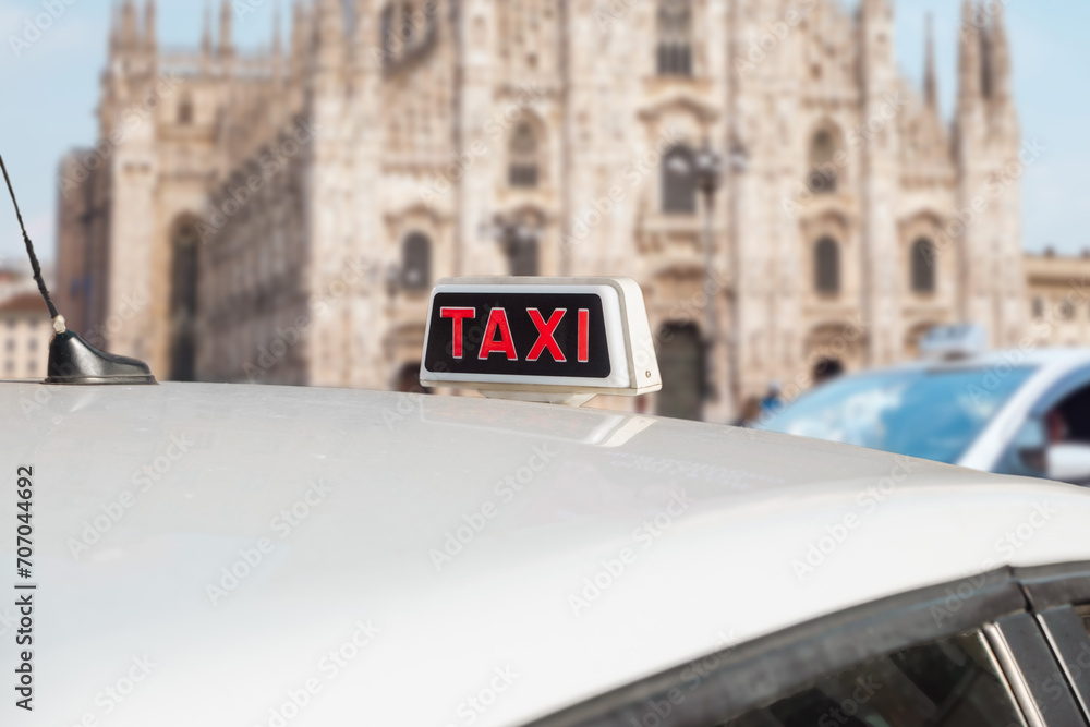 Fototapeta premium Taxi in Milan, Italy. Italian white taxi with sing on the roof.