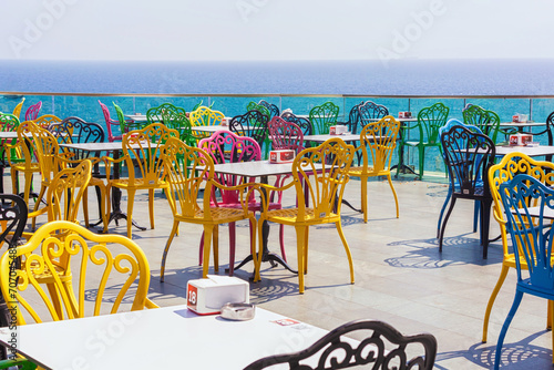 Colorful chairs in the restaurant with a view of the sea and the old town. Beautiful top view of the cafe, the Mediterranean Sea and the mountains. July 28, 2023. Antalya, Turkey (Turkiye) photo