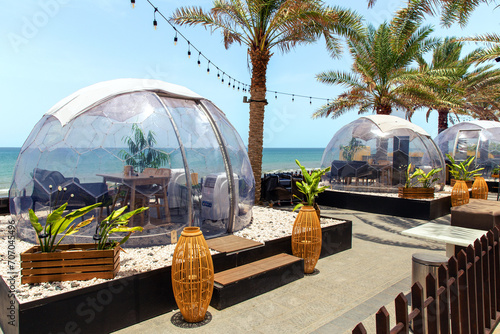 Transparent domed gazebo in the style of an igloo for romantic dates of lovers. Open air restaurant photo