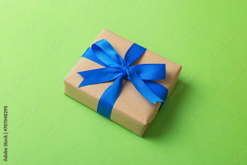 Wrapped christmas or other holiday handmade present in craft paper with colored ribbon. Present box, decoration of gift on table, top view with copy space Wrapped christmas or other holiday handmade present in craft paper with colored ribbon. Present box, decoration of gift on table, top view with copy space