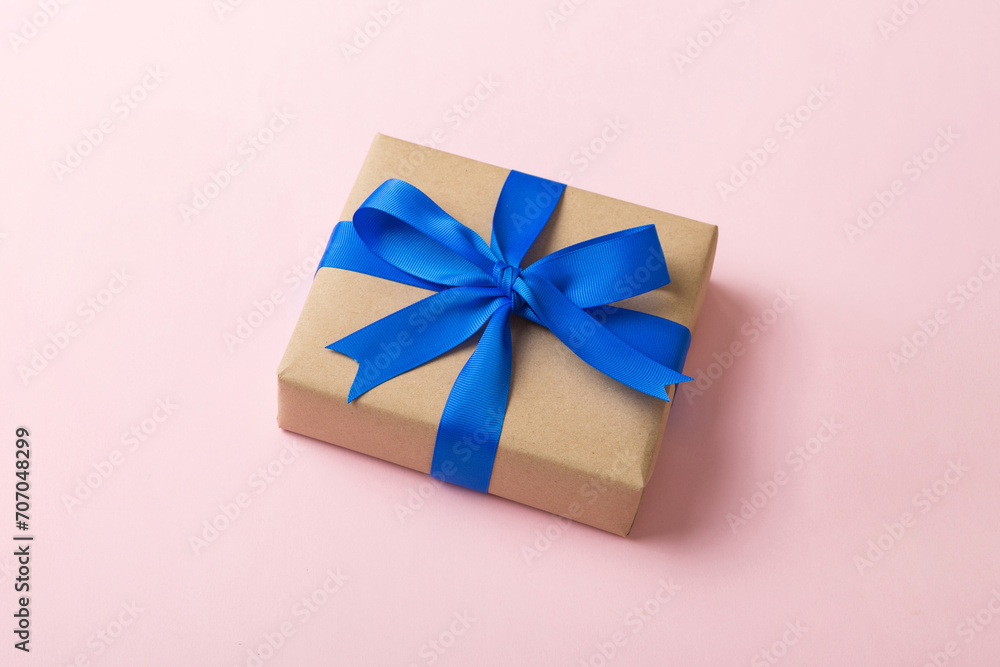 Wrapped christmas or other holiday handmade present in craft paper with colored ribbon. Present box, decoration of gift on table, top view with copy space Wrapped christmas or other holiday handmade present in craft paper with colored ribbon. Present box, decoration of gift on table, top view with copy space