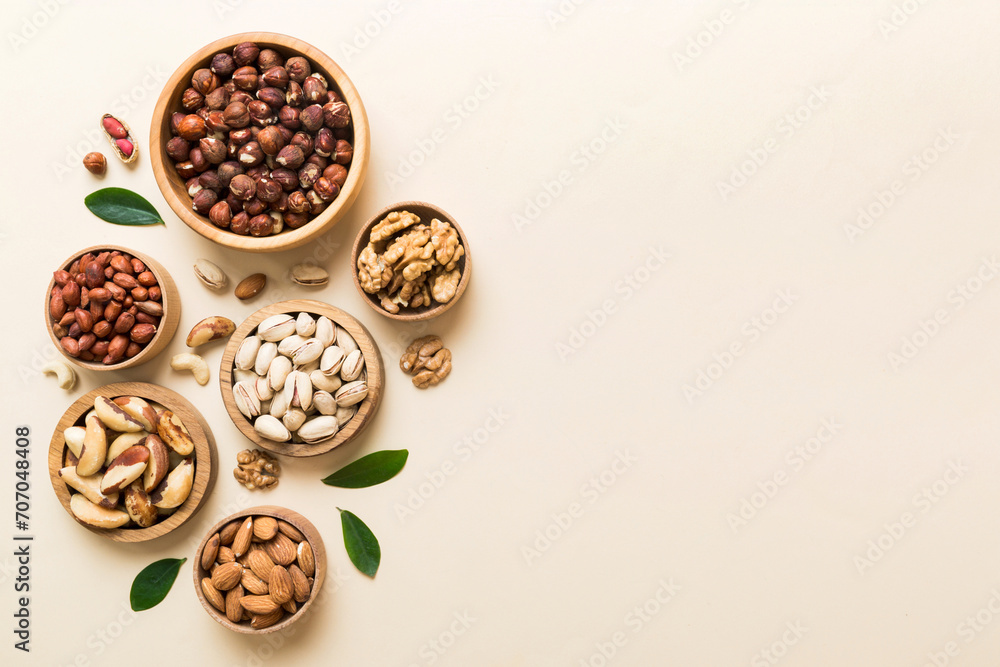 mixed nuts in wooden bowl. Mix of various nuts on colored background. pistachios, cashews, walnuts, hazelnuts, peanuts and brazil nuts mixed nuts in wooden bowl. Mix of various nuts on colored background. pistachios, cashews, walnuts, hazelnuts, peanuts and brazil nuts