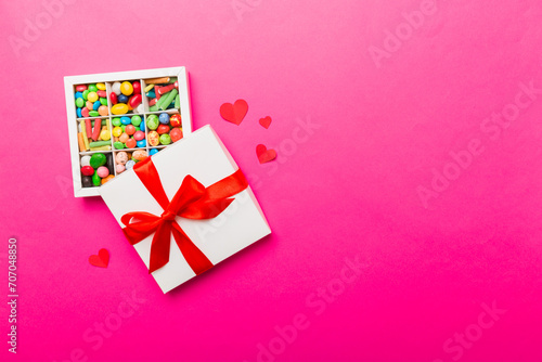 Valentine day composition: sweet candy, with gift boxes with bow and red felt hearts, photo template, background. Top View with copy space © sosiukin