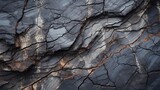 Textured Rock Formation with Natural Cracks. Close-up of a dark, rugged rock surface showing intricate patterns of natural cracks and veins.