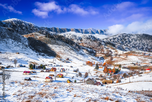 Carpathian Mountains, Romania. Charming winter snowy landscape with rural Rucar-Bran touristic region, Sirnea village and Piatra Craiului mountains. photo