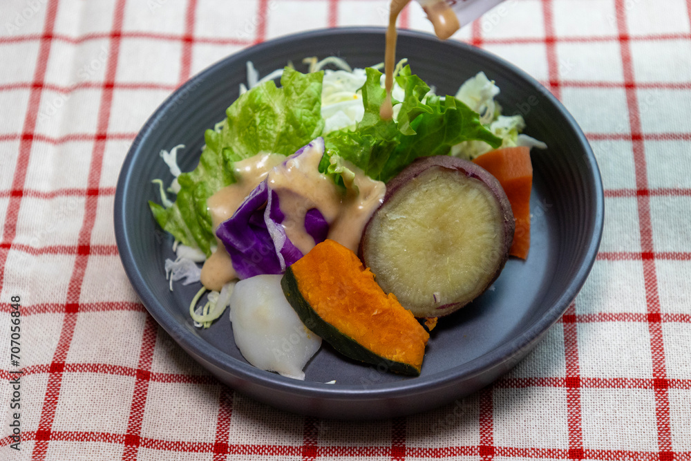 ドレッシングをかけたお皿に盛り付けた蒸し野菜のサラダ ドレッシングをかけたお皿に盛り付けた蒸し野菜のサラダ
