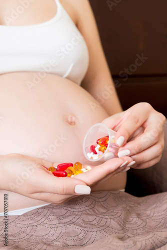 woman hand holding pills for improve of iron level in blood. Receiving vitamins in pregnancy time, Healthy millennial healthcare concept © sosiukin