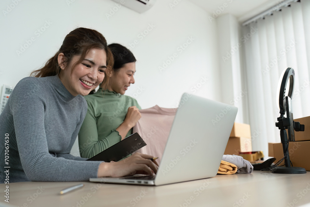 Young woman online business owner is typing details on a laptop in preparation for sending products to customers Young woman online business owner is typing details on a laptop in preparation for sending products to customers
