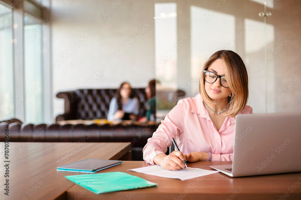 Young woman using laptop in office Young woman using laptop in office