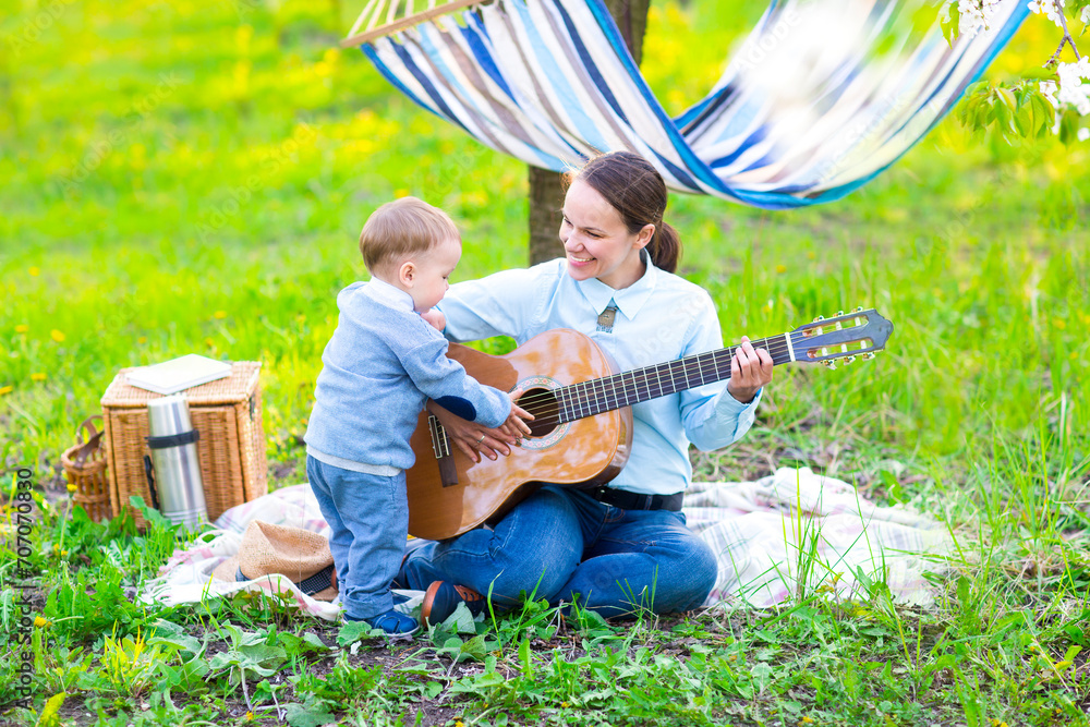Little baby boy with mother in the blossoming garden Little baby boy with mother in the blossoming garden