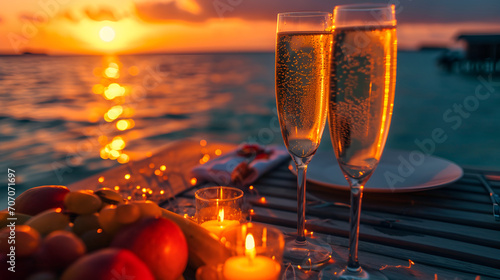 Romantic dinner at sunset on the seashore. Fruits and two glasses of champagne. Valentines Day Date