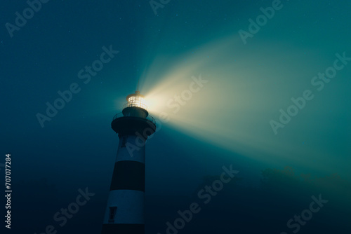 Enigmatic Beacon: Navigational Lighthouse Piercing the Veil of Night Mist