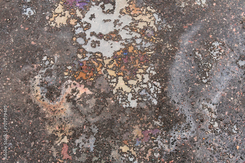 Spilling gasoline or oil on the asphalt in large drops as a texture or background Spilling gasoline or oil on the asphalt in large drops as a texture or background