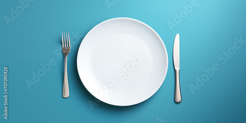 empty white plate with cutlery.  isolation on a blue background photo
