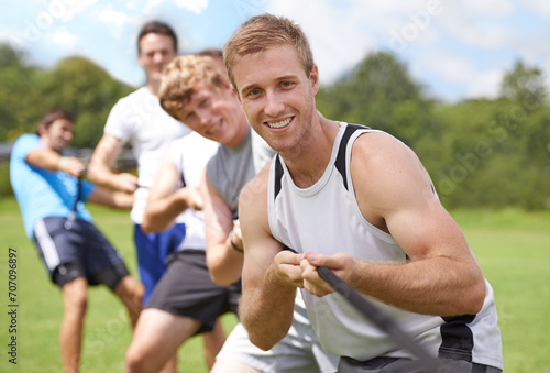 Rope, pull and men portrait with teamwork, tug of war and fitness outdoor on sport field. Training, workout and athlete group with support together for competition and strong arm exercise for health
