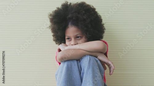 Unhappy girl, Sad child sitting hugging knees alone and lonely photo