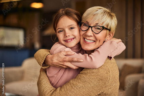 Φωτογραφία Grandma and her grandchild smiling for the camera, looking beautiful, sitting on the couch