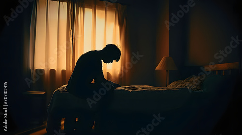 Silhouette depressed man sadly sitting on the bed in the bedroom. Sad asian man suffering depression insomnia awake and sit alone on the bed in bedroom. Depression health people concept. photo