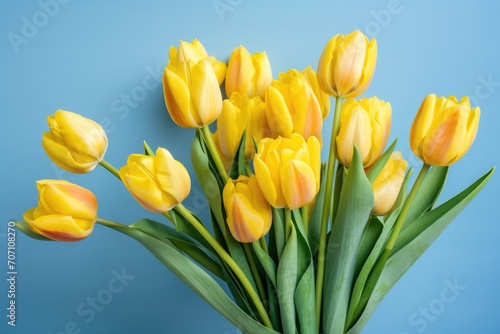 A bouquet of yellow tulips on light blue background. Beautiful spring flowers. Top view of a flat lay that is good for greeting cards for spring birthdays  Mother   s Day. Spring greeting card