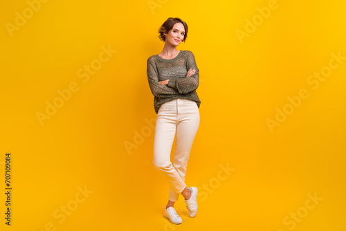 Photo of gorgeous cute girl dressed in fashionable outfit skinny denim pants isolated on vivid yellow color background photo