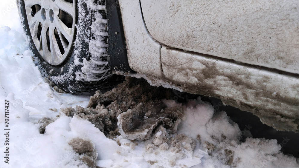 Car wheel on dirty messy snow. Mud, salt and chemicals on winter road. Ecology in city. Protection and wash auto concept. Environment conversation. Driving. Vehicle hubcap. Tire pressure. Tyre change. Car wheel on dirty messy snow. Mud, salt and chemicals on winter road. Ecology in city. Protection and wash auto concept. Environment conversation. Driving. Vehicle hubcap. Tire pressure. Tyre change.