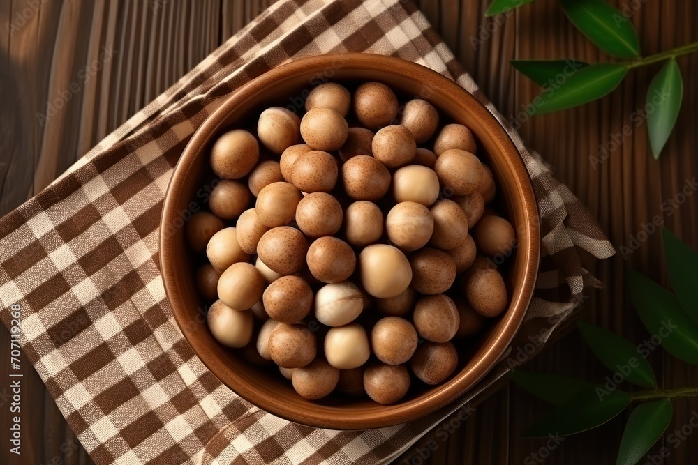 Tasty Macadamia nuts on brown table, flat lay Tasty Macadamia nuts on brown table, flat lay