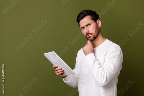 Photo of successful confident man wear stylish clothes hand touch chin solve tasks empty space isolated on khaki color background