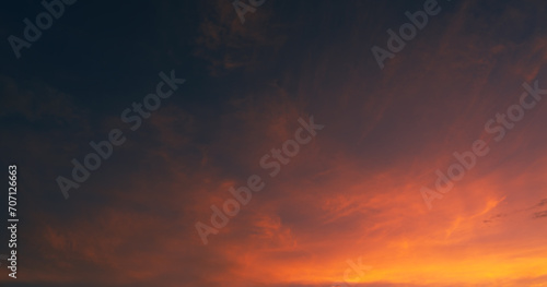 Dusk sky on twilight after sundown with horizon orange, red sunlight sunset clouds in golden hour and dark blue sky background 