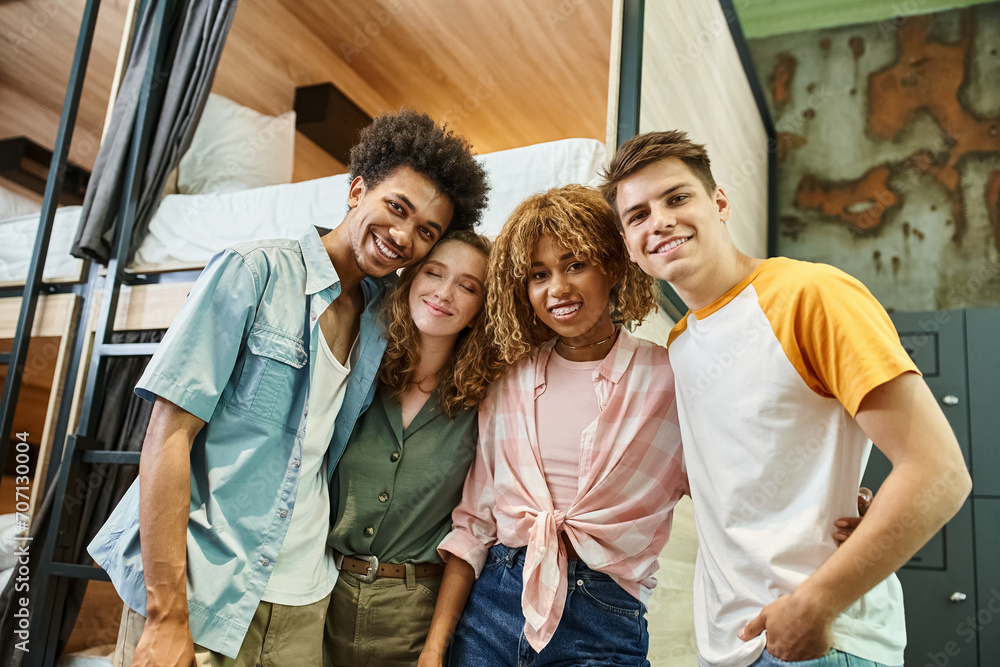 Fototapeta premium diverse group of multicultural students smiling at camera in room of modern hostel, friendship