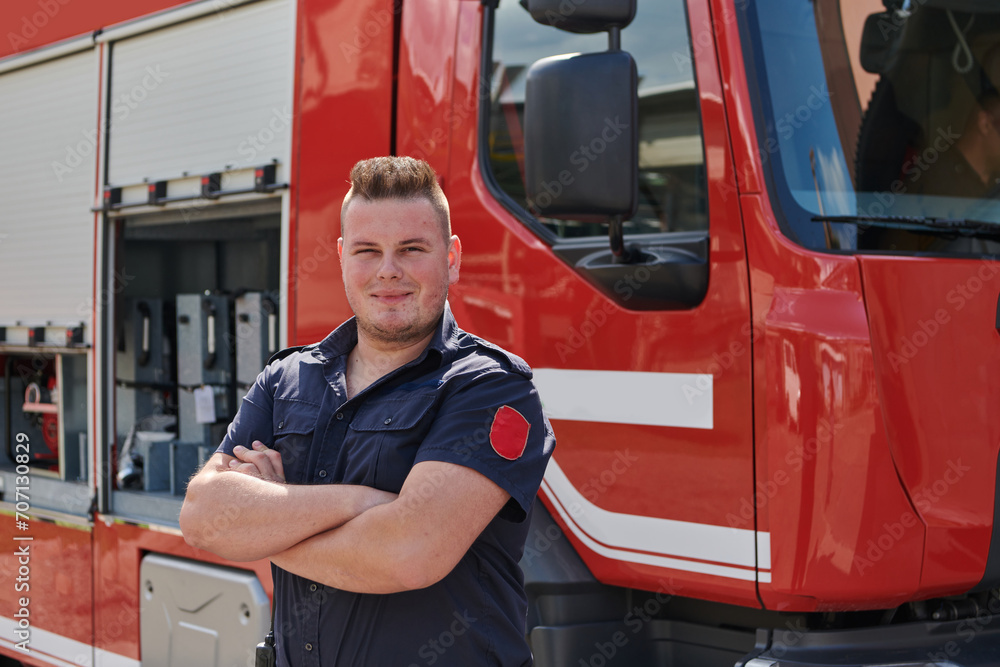 Confident firefighter stands with crossed arms, exuding resilience and preparedness, ready to respond to emergencies alongside a modern fire truck, showcasing the heroism and strength of the fire Confident firefighter stands with crossed arms, exuding resilience and preparedness, ready to respond to emergencies alongside a modern fire truck, showcasing the heroism and strength of the fire