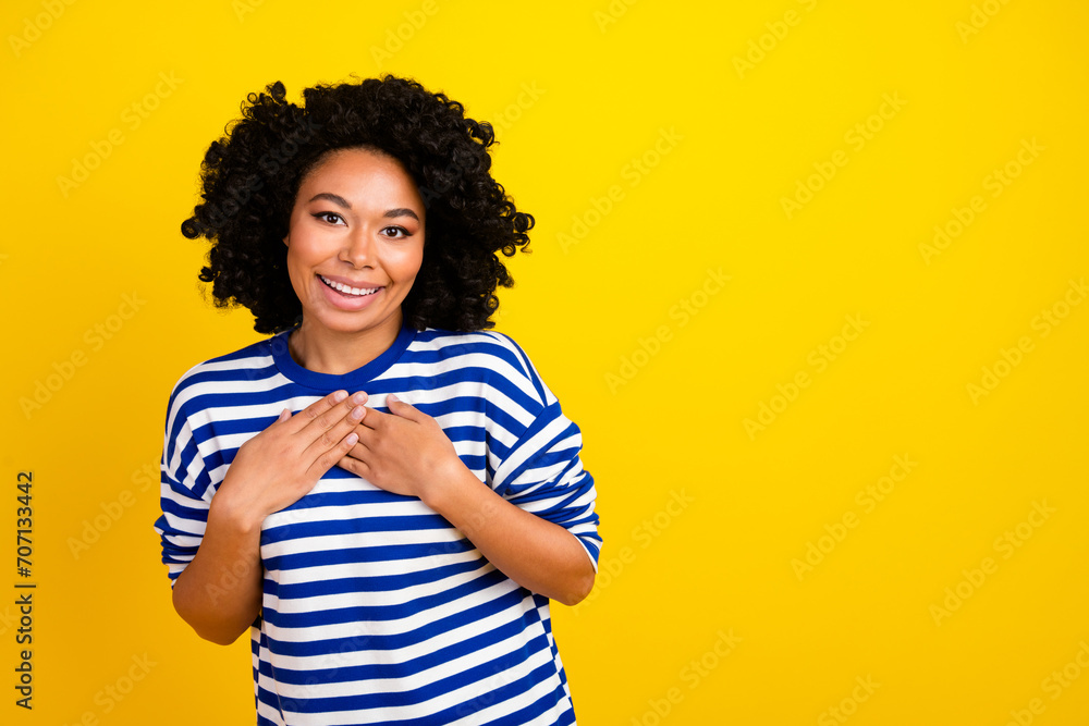 Photo of lovely adorable woman wear trendy striped clothes arm breast empty space isolated on yellow color background Photo of lovely adorable woman wear trendy striped clothes arm breast empty space isolated on yellow color background