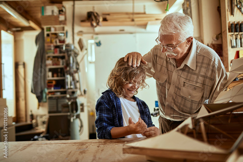 Grandfather and grandson working together in woodworking garage