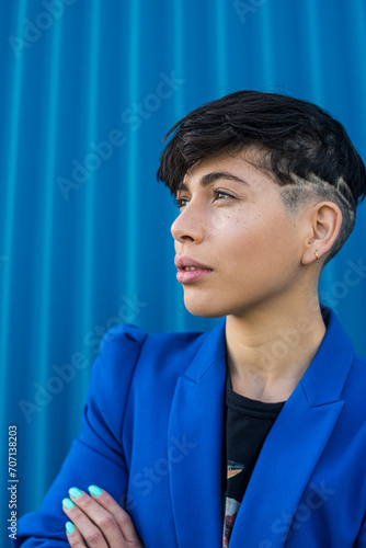 фотографія Androgynous young woman dressed in blue suit with empowering attitude