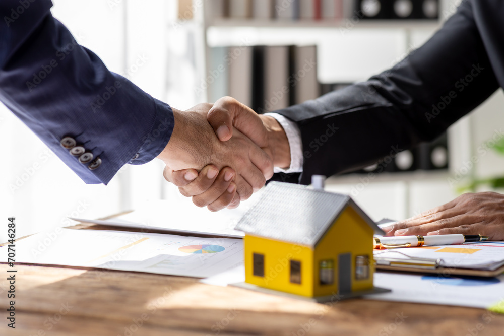 Real estate agent shakes hands with customer after finished contract after about home insurance and investment loan