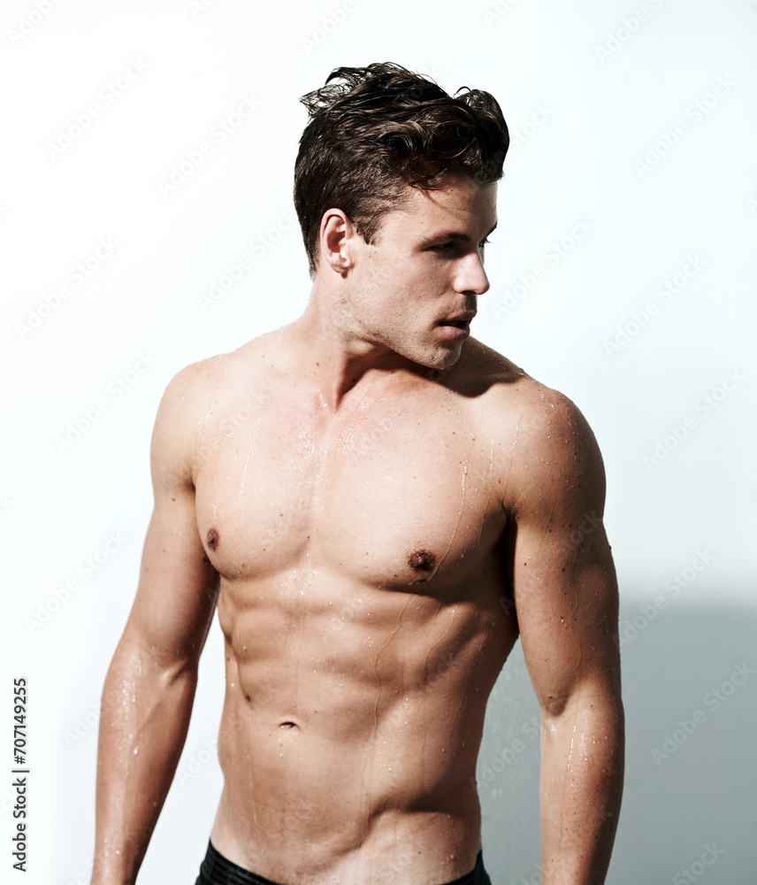 Shower, sexy and body of man with water for washing, cleaning and skincare wellness. Young, hot and muscular male model person with grooming and hygiene for healthy skin by white studio background.
