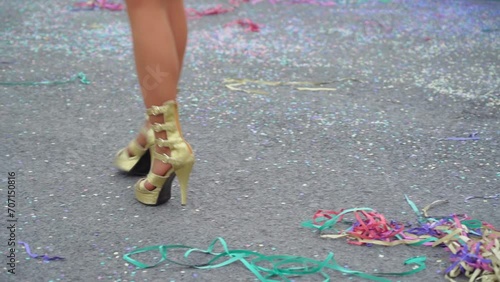 Women's graceful legs in suits and beautiful shoes dancing the samba at a fun carnival parade in slow motion and confetti on the floor. Close-up. photo