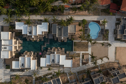 Top down aerial shot of resort  in golden morning light with swimming pools, beach, buildings and gardens.  A popular resort town in Vietnam know for windsurfing and kite surfing