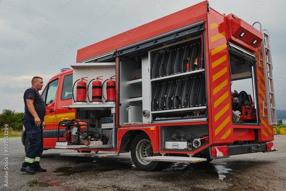 A dedicated firefighter preparing a modern firetruck for deployment to hazardous fire-stricken areas, demonstrating readiness and commitment to emergency response