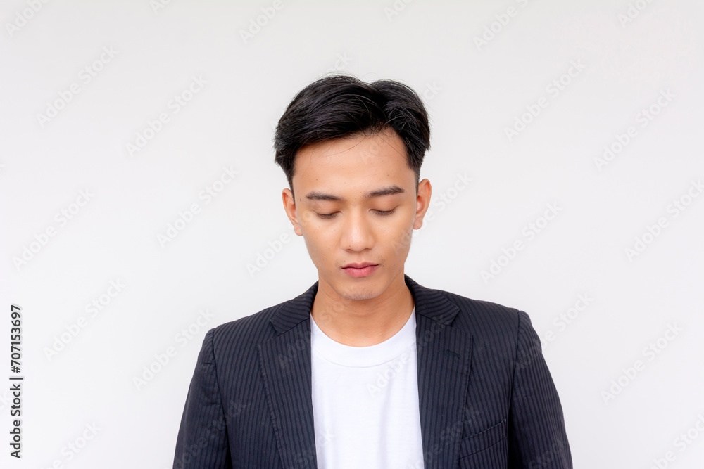 A young asian man looking disappointed in himself. Headshot isolated in a white background. A young asian man looking disappointed in himself. Headshot isolated in a white background.