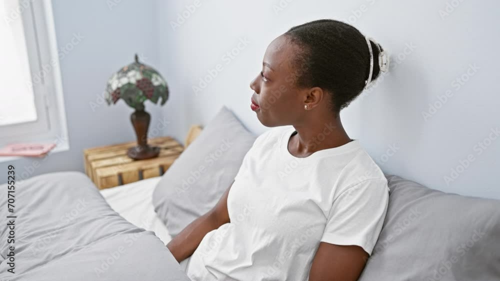 Cheerful african american woman relaxing in comfort, lying on bedroom bed with a cool, joy-filled smile on her face. perfect lifestyle portrait of a confident, positive lady. Cheerful african american woman relaxing in comfort, lying on bedroom bed with a cool, joy-filled smile on her face. perfect lifestyle portrait of a confident, positive lady.