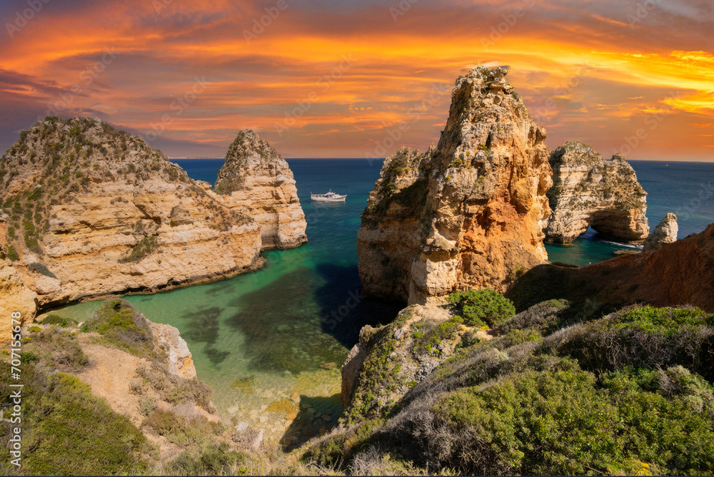 Sunset at Algarve Coast, Majestic Limestone Cliffs Rising from Turquoise Waters with Leisure Boat