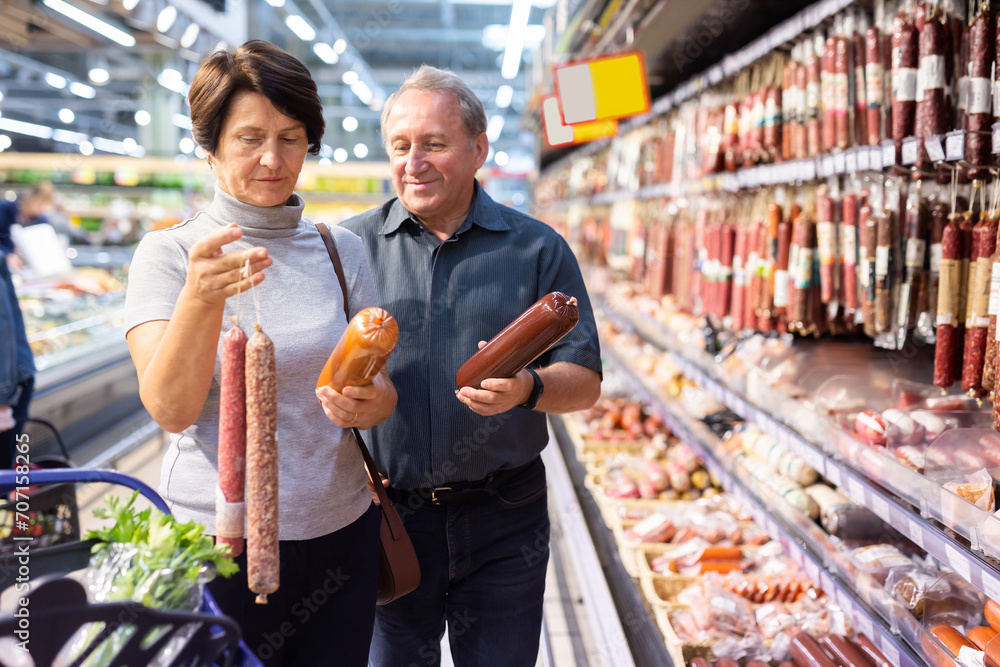 Obraz premium Elderly man and elderly woman choose sausage