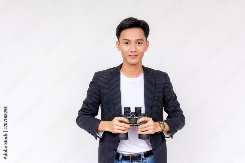 A handsome young asian man holding a pair of binoculars. Isolated on a white background. A handsome young asian man holding a pair of binoculars. Isolated on a white background.
