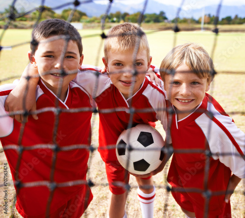 Kids, soccer team and portrait with smile, goal net and boys with teamwork, support or solidarity. Energy, sports and friendship, together and happy for win, ready for game and physical activity